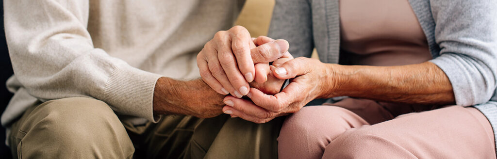 concerned older couple holding hands 