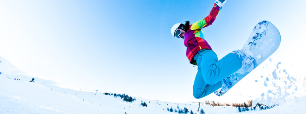 Snowboarder preforming an extreme jump.